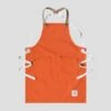 Orange Children’s Apron 1 Orange Children’s Apron -Home And Daily Necessities Store risdon and risdon childrens studio apron orange cork grey background 600x600 1